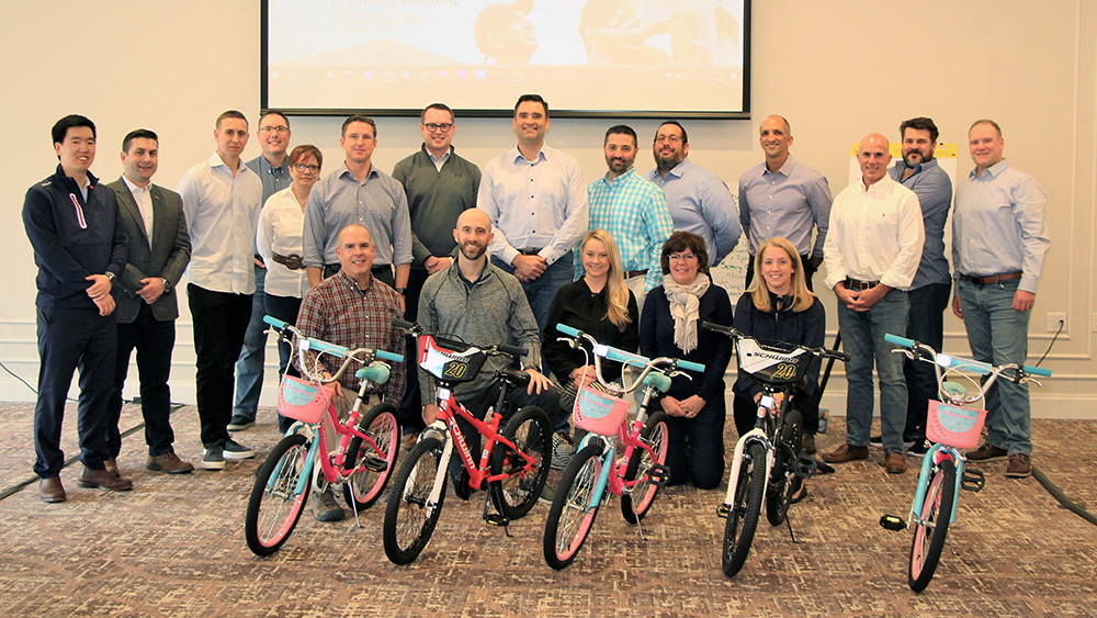 Pictured: Staff from Charles Schwab assemble new bikes for children The Village serves as part of a team building activity.