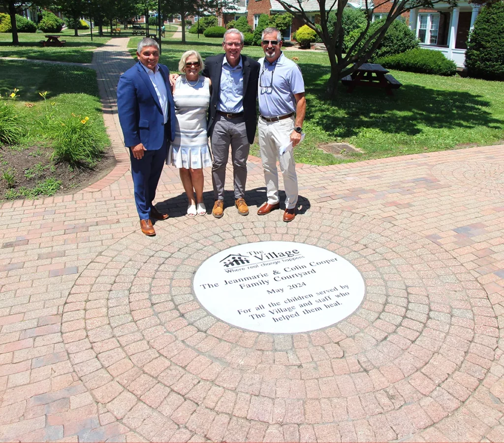 Pictured: (L-R) Village President & CEO Hector Glynn, Board Member and Donor Jeanmarie Cooper, Donor Colin Cooper and Board Chair Curt Cameron stand in the newly named “Jeanmarie & Colin Cooper Family Courtyard” in honor of the Coopers’ legacy gift to The Village.