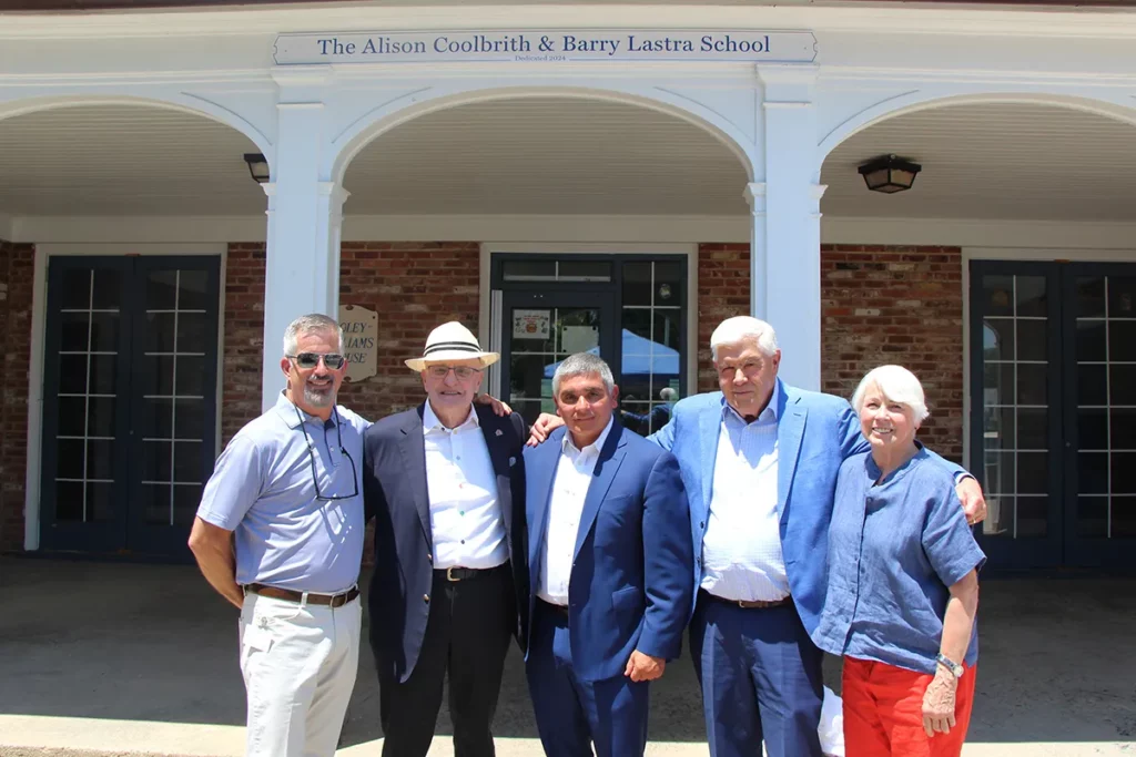 Pictured: (L-R) Village Board Chair Curt Cameron, Board Member and Donor Barry Lastra, President & CEO Hector Glynn and Lastra’s family members Peter and Connie Gallagher in front of the school named in honor of Lastra and his late wife Alison Coolbrith for Lastra’s legacy gift to The Village.