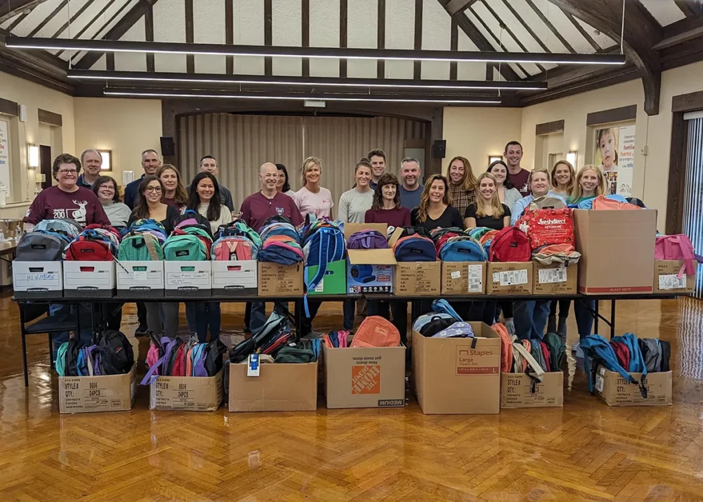 Volunteers from The Hartford helped The Village prepare hundreds of backpacks with school supplies like pencils and notebooks so they could be given to local families before the new school year.